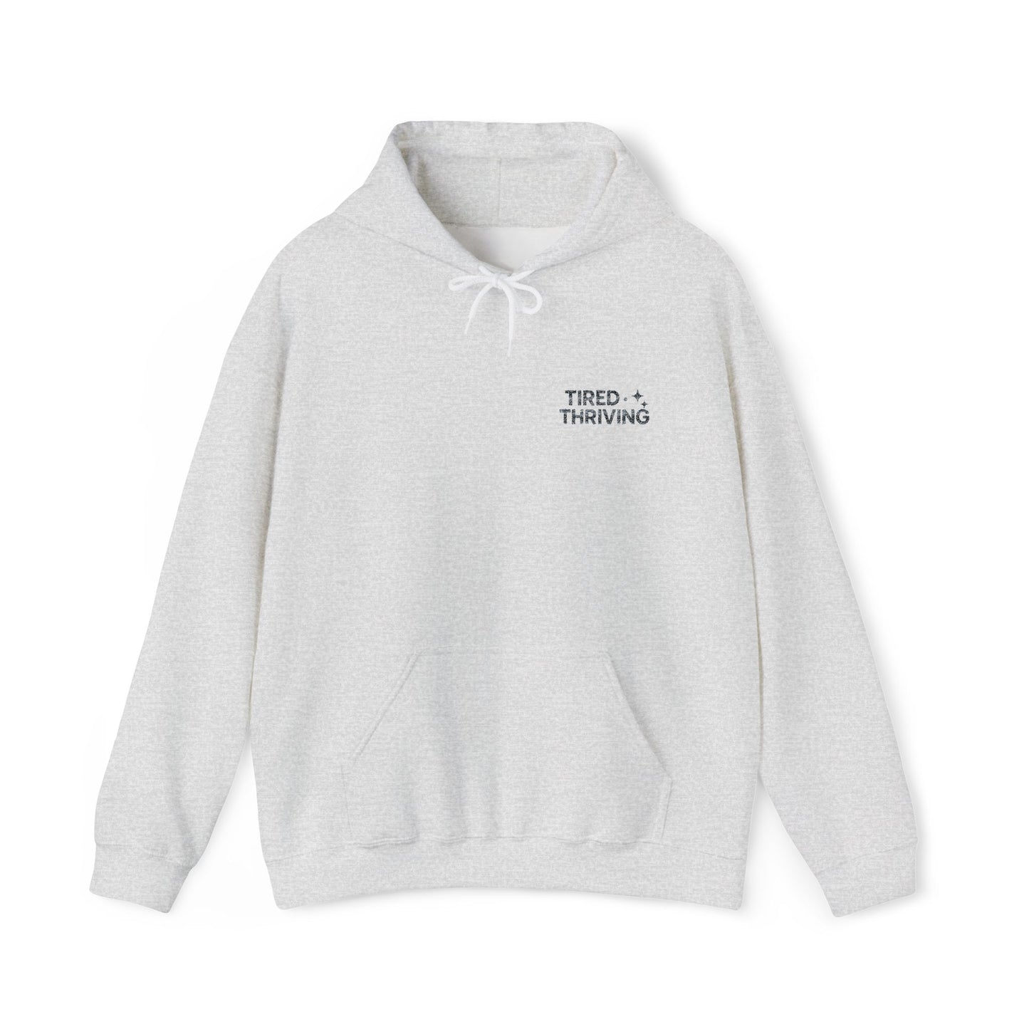 Minimal “Tired + Thriving” Embodied hoodie. Cozy fleece, unisex fit, durable chest graphic—everyday streetwear for busy days that still thrive.
