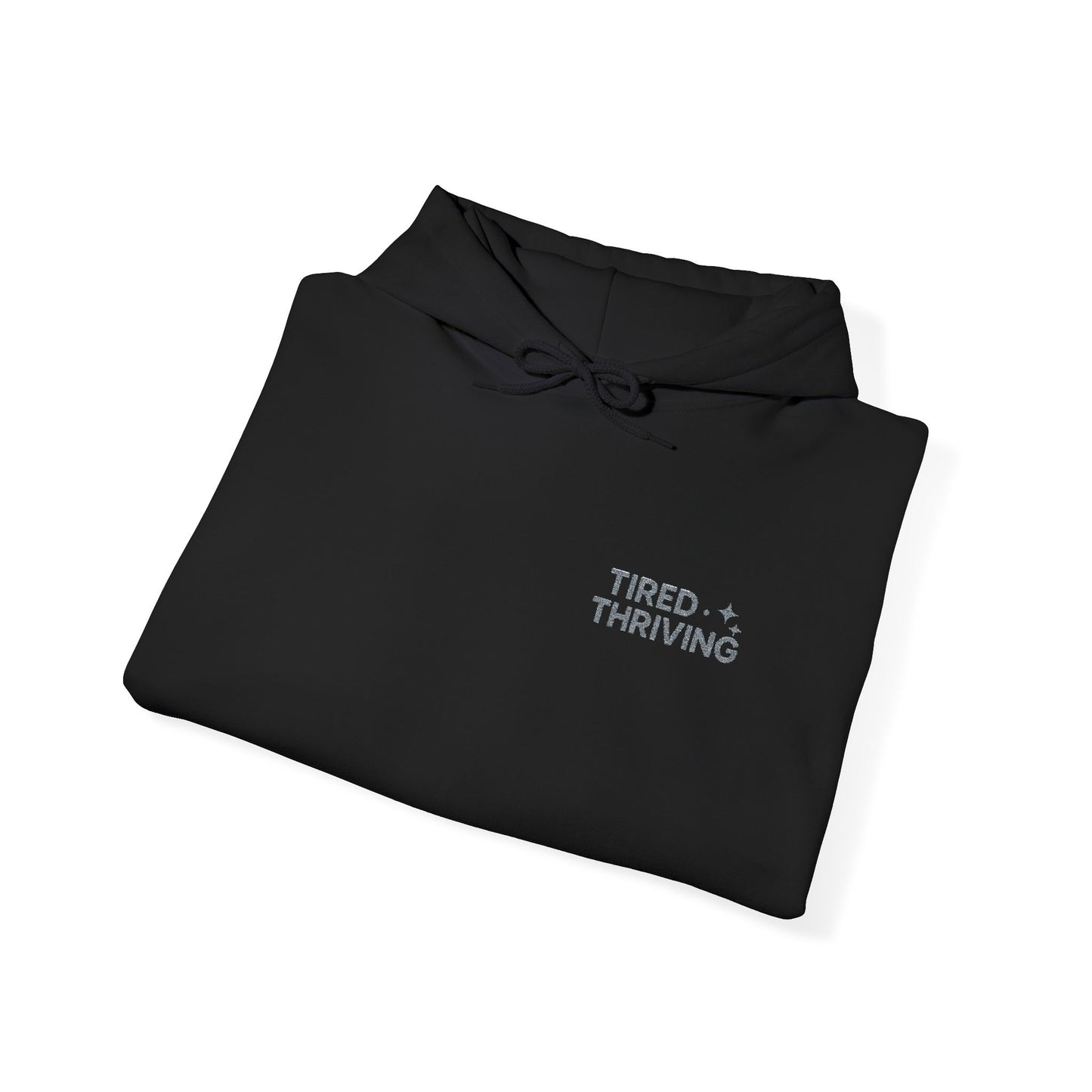 Minimal “Tired + Thriving” Embodied hoodie. Cozy fleece, unisex fit, durable chest graphic—everyday streetwear for busy days that still thrive.